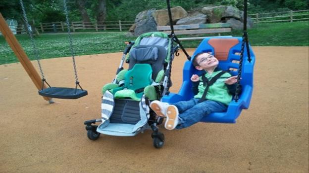 Child on disability swing in playground